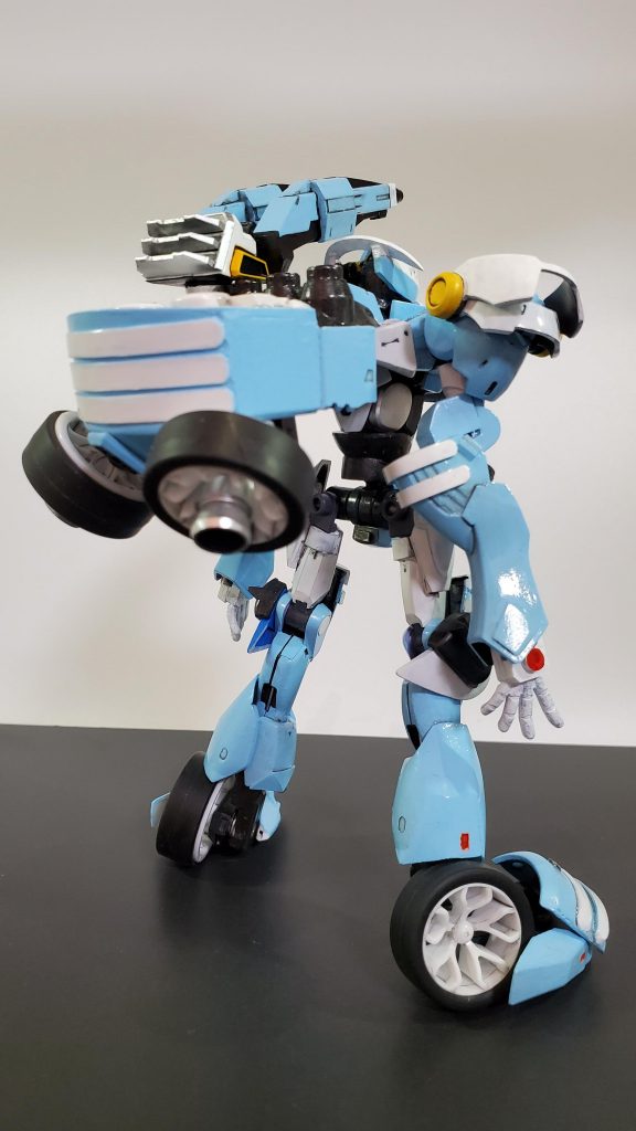 背面■機体概要・頭部ブレイヴの頭部に強化センサーゴーグルを搭載。また、グラビカルアンテナはアーチ状に改造されている。・胴体ブレイヴがベースだが、可変機能の都合上前後逆向きで使用している。胸部には装甲を追加し、元々低い防御力を底上げしている。・背部ユニット大型コンデンサーと、4基のウェポンラックを搭載しており、大型コンデンサーからの粒子供給により大火力のビーム兵装を使用可能。・肩部ブレイヴをベースに、可動式の装甲を追加。装甲を畳む事でリフボードを懸架することが可能。・腕部フラッグをベースにリフ時のバランス制御の為に、下腕部を延長。・腰部股関節はブレイヴをベースに、可動軸を変更。胴体との接続部にフレームを追加し柔軟な可動が可能になった。・脚部陸戦型フラッグをベースに装甲を追加、膝横のハードポイントに三連装ホーミングレーザーを搭載可能。足首のフレームは変形用に変更されている。