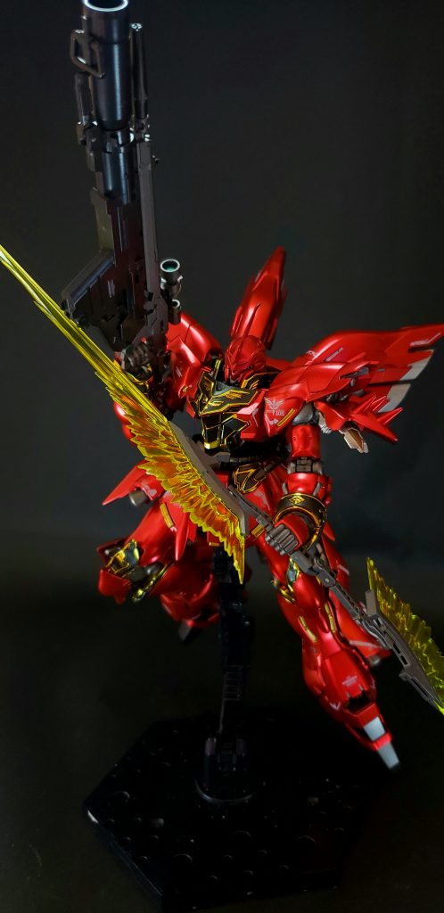 元々はサイコフレームをメインフレームに据えたMSの、一般パイロットの操縦では計測不可能な限界値を取得するべく、機械上での試験運用を目的とした実験機で、驚異的な機動力と追従性を誇るも、発生する加速度（G負荷）によるパイロットへの肉体的負荷は殺人的なレベル[注釈 5]で、なおかつインテンション・オートマチック・システム制御のサイコミュによる精神的負荷もあるため、並のパイロットにはまず乗りこなせない“極めて端的な[12]”MSであったとされている。その限界値を突き詰めた設計ゆえ、人間が乗り込む機動兵器としては欠陥機とも言えるMSであったが、実際には人を超えた「ある者」に向けて造られていたとされる[13]。強奪に偽装した譲渡という形でネオ・ジオン残党軍「袖付き」の手に渡り、「赤い彗星の再来」と渾名され、ニュータイプとしてもMSパイロットとしても高い能力を誇るフロンタルが操縦することで、あくまで理論上であったそのポテンシャルを、作中の戦闘にて遺憾なく発揮することとなった[14]。