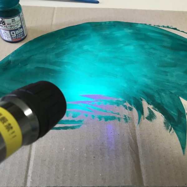 フェネクスの「光の翼」工作中の様子です。普通のA4クリアファイル（ポリプロピレン製）をハサミで適当に切って、ガイアの蛍光ブルーグリーンを大胆に筆塗りしました。塗る前に表面にはヤスリをかけました。ブラックライトで光ります(^^)