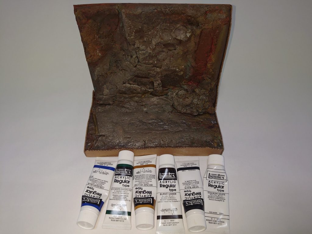 塗装は筆+スポンジ塗装チタニウムホワイト、アイボリーブラック、バーントアンバー、ブロンズイエロー、フーカスグリーンヒュー(緑)、セルリアンブルー(青)レッドオキサイドもほんの少し使ってます。・トレーを裏返して後ろに段ボールを貼り付け、壁紙シートを貼る。・紙粘土で隙間を埋めつつ、スポンジで凹凸を作る。・紙粘土の白をなくすように茶色系で塗りつぶし、青や緑、白を上から全体に塗りつける。・最後に段ボールシートをトレーと壁紙シートに沿って切断、ボンドで接着。ジャブローは岩が灰色から青のイメージですが、ミネラル(鉄分とか)を含む地下水があると赤茶色になったり苔むして緑になったり、土があれば茶色になるのでわりかし遊んでます。制作時間は、合計1時間判程度。