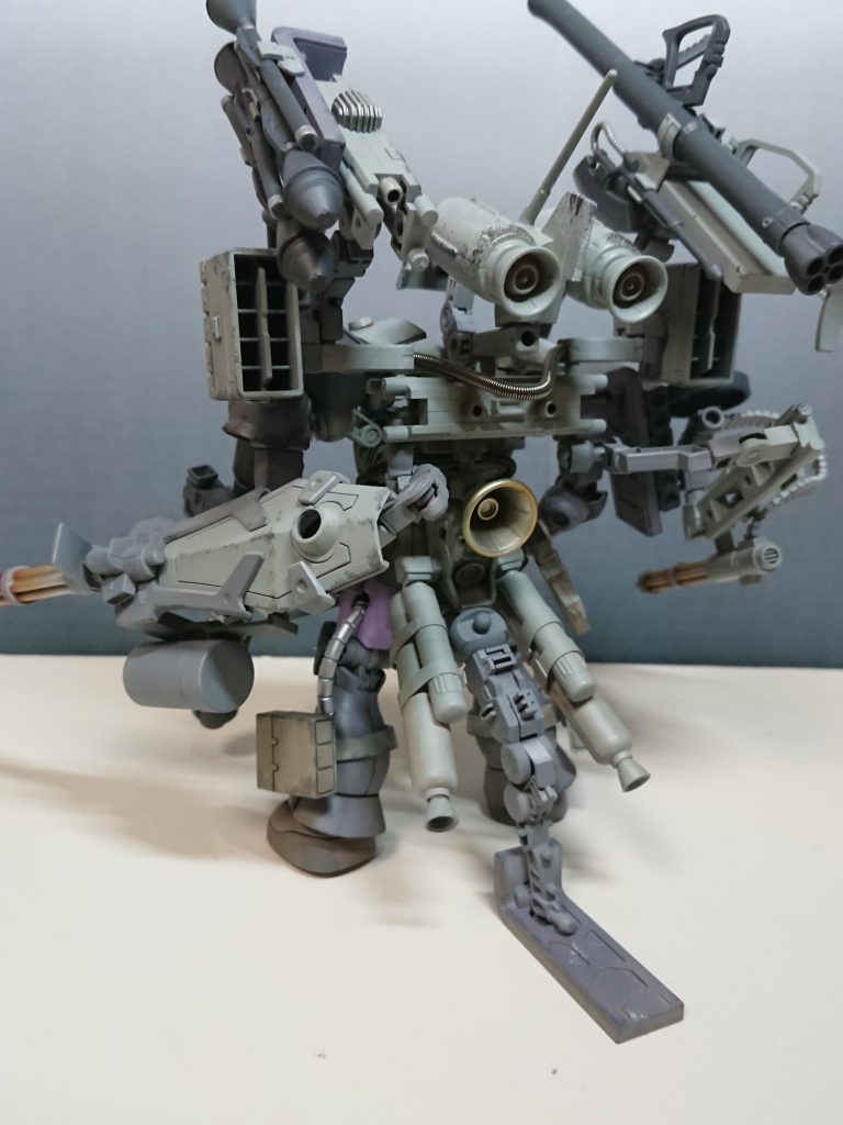 背面ズゴックEやハイゴッグの共通装備ジェットパックと、大量の武装を使用するための安定脚を装備