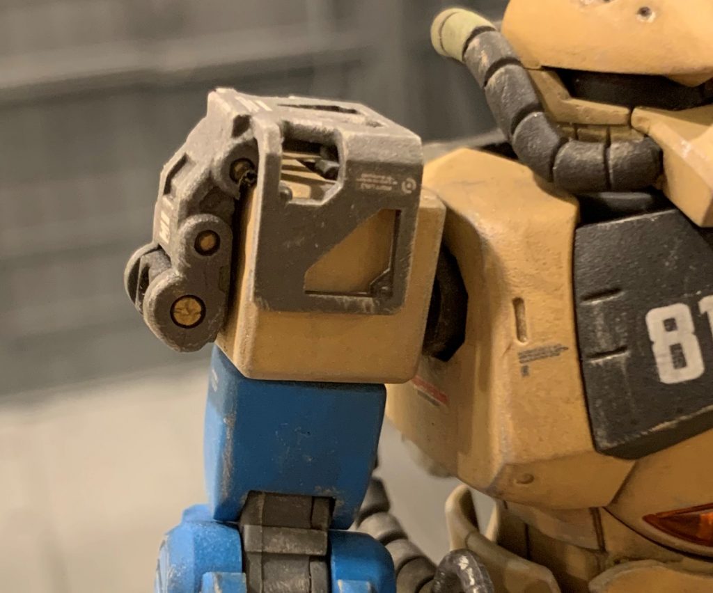 右肩はバズーカを担いだり射撃した際の衝撃を吸収するショックアブソーバを、メカニックが現地の有りものでこしらえた設定です。元々肩はタックルしたりする前提なので、肩ジョイントは衝撃に強い設計だと想像し、火器使用時の衝撃を腕ジョイントに直接ではなく丈夫な肩ジョイントを介す構造、というイメージで作りました。補給の少ない貧乏前線基地で、部品損耗を効率化する為の現地メカニックの涙ぐましい努力の結晶といったところです。RGザクのジョイントパーツに、オリジンHG旧ザクの肩プロテクターをくっつけました。旧ザクプロテクターはそのままだとグフの肩に入らなかったので、一度中央で切断しプラ板を挟み接着し幅増ししています。 +