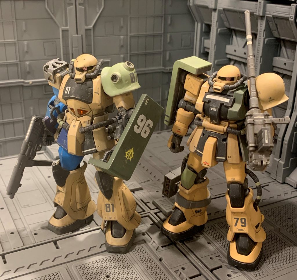 前回のグフと並べてみました。グフは生産拠点が月のグラナダと北米西海岸のキャリフォルニアベースだったので(公式設定)、アフリカへの部品供給は困難だったはずで、前回投稿のグフは在庫消耗を惜しんで多少被弾した部品も交換せずそのまま使っている演出をしました。対してF2ザクはアフリカへ多く配備されていたという公式設定があるので、おそらくキリマンジャロ基地でも部品が製造されていたと考えました。部品が潤沢に補給されるのでダメージを受けた部品は都度交換され、F2ザクは常に良好な整備状態で稼働出来ていたと考え被弾痕は無し、グフよりは全体的に少し小奇麗にしてみました。キリマンジャロ基地では生産効率を考え一律ノーマルカラーで生産し各前線に供給され、前線の現場単位で色を塗り替えていたという設定で、塗装が間に合わない場合はノーマルカラーのまま運用されていた、という感じの妄想です。
    +