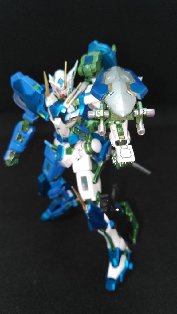 複合兵装GNシールド改シールド裏にビームサーベル二本を収納。GNマシンキャノン２門搭載。腕部GNバルカンと共に粒子弾をばらまく近～中距離における制圧射撃を行う。