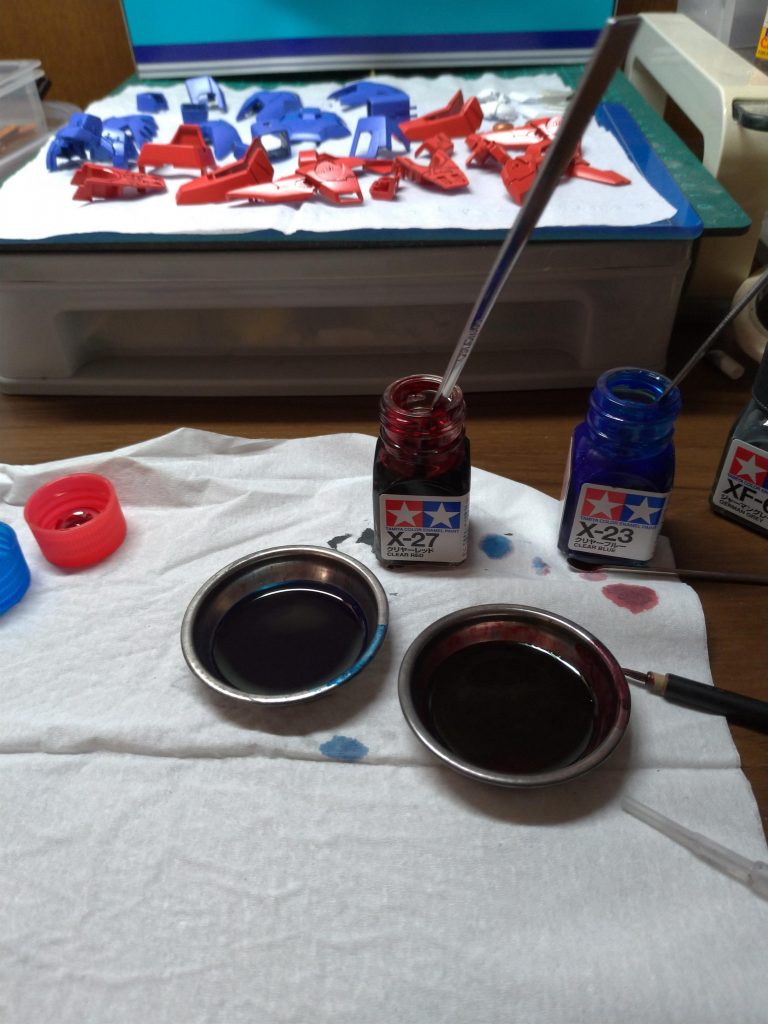 スミ入れの話。今回赤・青パーツのスミ入れは上写真のようにクリアーレッド+クリアーブルーの調色で行いました。比率を変えて2色作っており、赤パーツにはクリアーレッド多めのレッドパープル寄りの紫、青パーツにはクリアーブルー多めのバイオレット寄りの紫で行ってます(比率はそれぞれ3:1程度)。黒~グレー系でスミ入れするよりも濁りがなく、パーツの色に自然に馴染むようになったと思います。