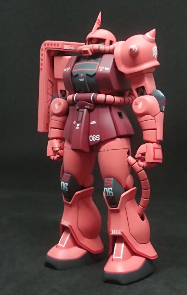 あらためて前面。大問題だったのが膝と肘の「S」の字。赤いアルファベットデカール自体が希少な上、カクカクとしたフォントのものがないという。レーザープリンターで自作しても下地が黒いとまともに発色しないんですよね。今回は、紙やビニールシートを切り抜くカッティングプロッターというものを導入してみました。これでハセガワのフィニッシュシートを文字の形に切り抜けば一発じゃん？と・・・ところがそうは問屋が卸しませんでした。極薄な上に伸縮性に富むフィニッシュシートは、カッティングプロッターで切り抜こうとすると刃に絡みついてぐちゃぐちゃになってしまうんですね。サイズが小さく複雑なのも原因だったかもしれません。色々試行錯誤した結果、フィニッシュシートの上からタミヤのマスキングシール（大型で１枚物のマスキングテープ）を張り付け、伸縮性をある程度殺してやった状態で切り抜くと、だいたい1/3～2/3の確率で成功しました。・・・やっぱり自作デカールだけで再現するのは厳しい時があるなぁとところでこの画像のザク、メイン画像とは違う所があります 