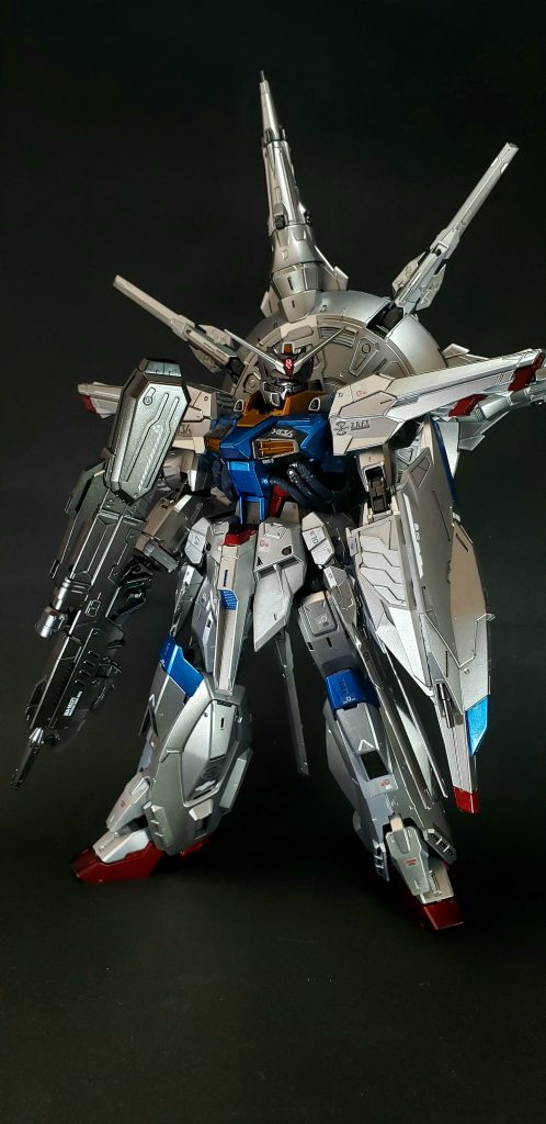 しかしながら、豊富な核エネルギーの活用や、パイロットが空間認識能力の高いラウに決まったこともあって、急遽ドラグーン・システム搭載機に変更された[4]。ドラグーン・システムの搭載は機体の基本設計が完了した後に決まったため[8]、重量の増加に伴いスラスターの出力を強化し、機体背面及び腰部側面に、外部ユニットとしてドラグーン・プラットフォームを搭載された[4]。