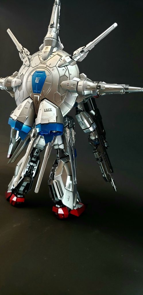 機体構造編集頭部額にはイタリア語で11を指す「UNDICI」（ウンディッチ）の文字がある。これはプラントでMSを実用化した技師がイタリア系であった事に因む[10][注 4]。ブレードアンテナ付近には搭乗者のラウ・ル・クルーゼの仮面を模した形状のフェイスカバーが存在する[7]。コクピットジャスティスやフリーダムでは胸部に搭載されていたコックピットが本機では腹部に搭載されており、これもドラグーン・システムの搭載による仕様変更だといわれている[7]。コクピット規格はジャスティスやフリーダムと同一[11]。マルチロックオンシステムも搭載する[4]。OSOSには他のザフト核機動ガンダムと同様、「G.U.N.D.A.M.COMPLEX」を搭載する[12]。