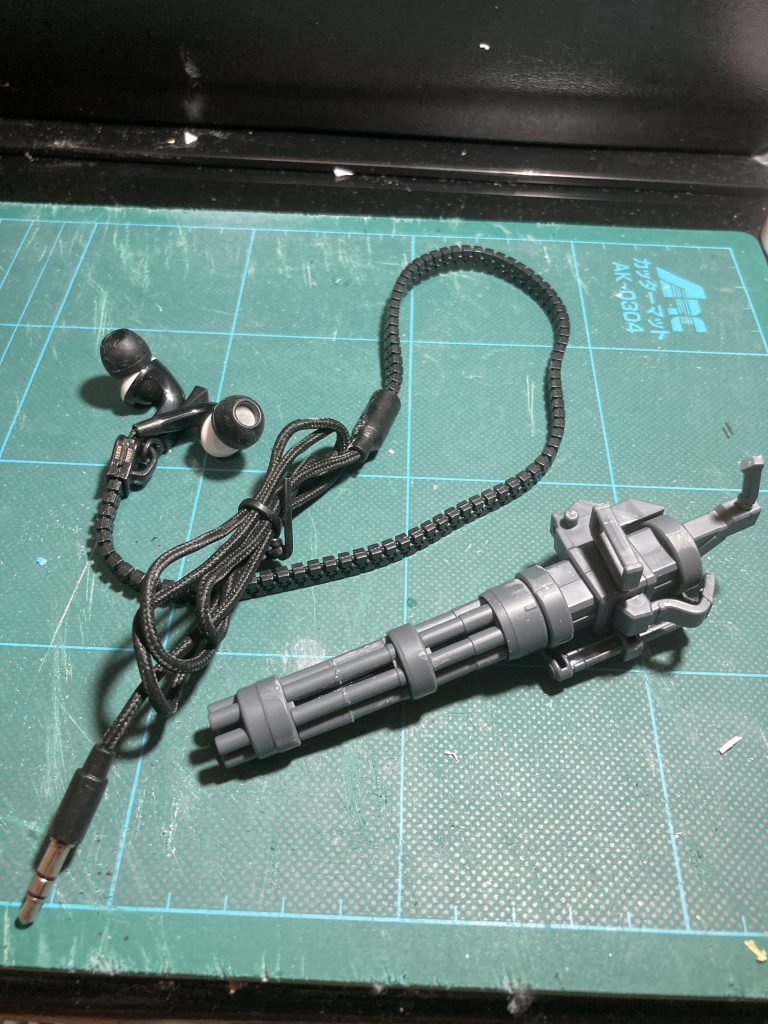 ガトリングのキットには給弾ベルトがついていなかったので、代用品を探したところ100均に売っていたファスナー型コードのイヤホンが使えそうだと思い取り付け。サイズ的にもぴったりだったので採用。近くで見たらモロにファスナーだけどこまけぇこたぁいいんだよ!!