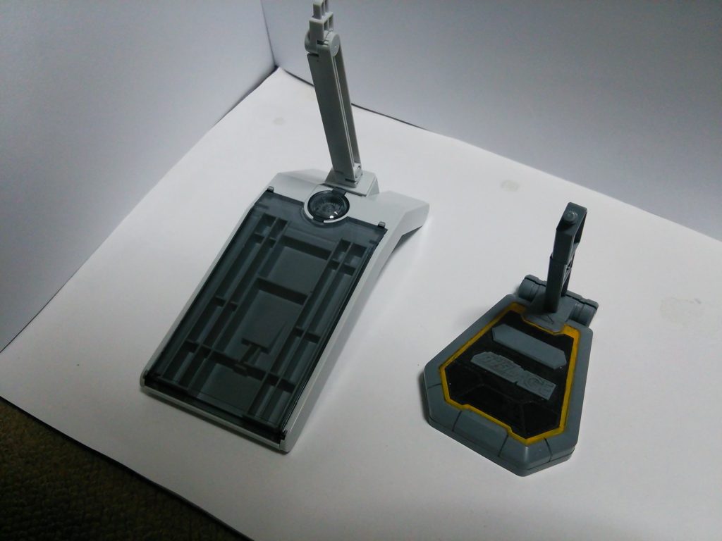 まずはＧＰベース。組み上げた状態。隣は2011年夏に配布された非売品・ＡＧＥデバイスプラモ。「ビルドファイターズ」作中のＧＰベースをディスプレイベースとして立体化。現在も適度に再販があります。スタンドとしては簡易的。根元とキット側の半固定アームを持ち、先端は３ミリ軸で固定されます。 