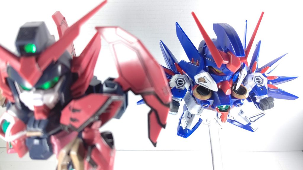 『SDガンダム GGENERATION』シリーズのオリジナルMSで、エピオンの支援を目的に開発された機体。アクエリアスとはみずがめ座を意味する。対MD用の電子戦装備「アンチMDシステム」を搭載している。これは本機から半径10km以内に存在する全MDにコンピュータウイルスを送信し、機能障害を発生させる。アクエリアスがMDを行動不能に陥れ、エピオンがその間に有人の指揮機を撃破するという戦法が考案されていた。ジェネレーター出力の大半をシステムの稼働に費やしているため、「本体からのエネルギー供給を必要とするビーム兵器」は使用しない。また、システム自体も大型なため自重が増加しているが、大気圏内飛行が可能なほどの大出力スラスターを搭載しており、エピオンに追従できるだけの機動性は備えている。この機体は幽閉されたトレーズの支持者によって開発された機体であるが、実戦には一度も参加しない。一説によると、デルマイユ派によって開発者ごと闇に葬られたともいわれる。(※wikiより)この写真の元ネタ分かる人いるのかな・・・