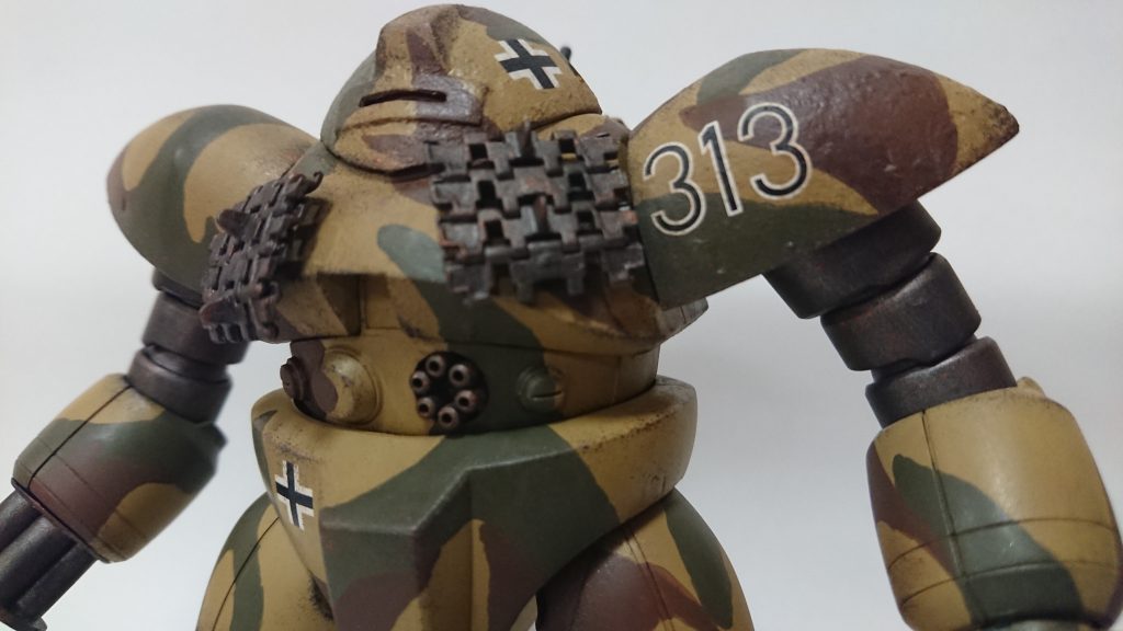 頭部、胴部、肩部はラッカーパテで鋳造表現を施しました。胴部には戦車のキャタピラを付けて増加装甲の代わりに。頭部はモノアイ部分を改造して小窓風に変更してます。腹部メガ粒子砲はディテールパーツを用いて機関砲に変更。D型は左側一門のみ、他の型は二門かもしれない…両端の魚雷発射管は戦車模型のパーツを使い、前照灯に変更しています。