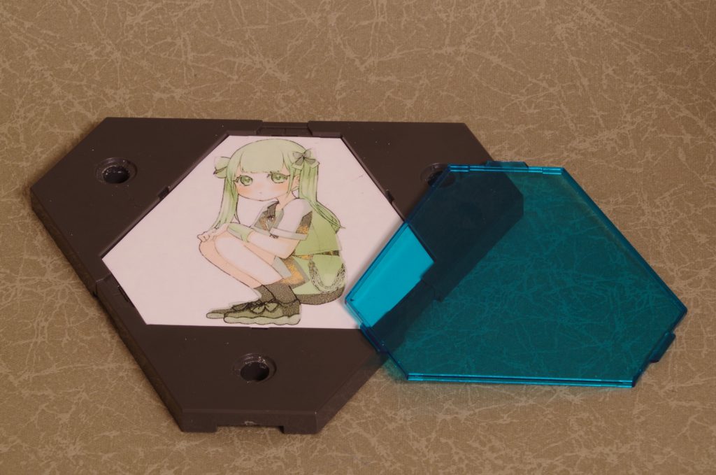 ベースには公式で使われているキャラクターイラストをA-oneの転写シールの用紙にプリントし、ベースのくぼみの形に合わせて配置しました。当初は部品に転写しようと思ったのですが、そのまま挟んだほうが良さそうだったので方針転換