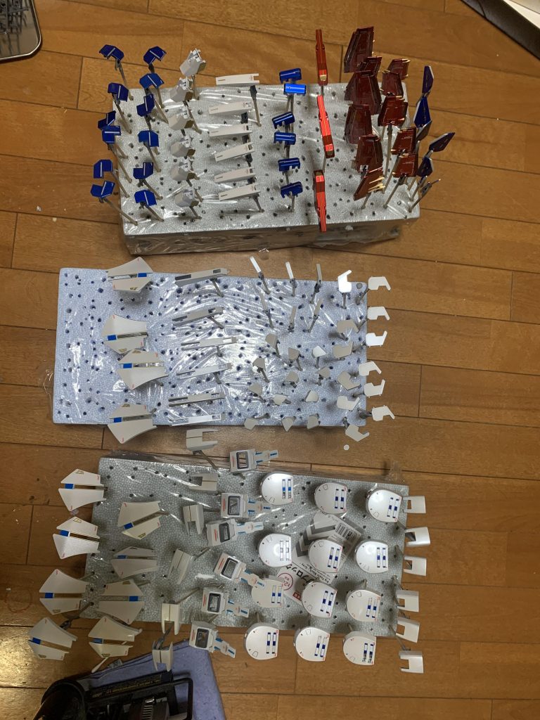 一度に全てのパーツを塗装せず小分けにして３体同時に塗装しました。理由は、１機ずつ制作すると配色、色に大きくバラ付きが出ると考えたからです。それでも、かなりのパーツ量でした(^^A;カラーレシピです。＜白い箇所＞クレオスさん　黒→ガイアさん　Exシルバー→ガイアさん Exホワイト→クレオスさん　ホワイトパール →クレオスさん　ムーンストーンパール→クレオス　ダイヤモンドシルバー→クレオスさん　クリア→トップコート　クリア（3回）＜胸部等の青い箇所＞クレオスさん　黒→ガイアさん　Exシルバー→ガイアさん Exホワイト→クレオスさん　ホワイトパール →クレオスさん　ムーンストーンパール→クレオス　ダイヤモンドシルバー→クレオスさん　クリアクレオスさん　ディープクリアブルー→トップコート　クリア（3回）＜ダクト等の黄色い部分＞クレオスさん　黒→ガイアさん　スターブライトゴールドつまさき等の赤い部分クレオスさん　黒→ガイアさん　Exシルバー→クレオスさん　クリアーレッド