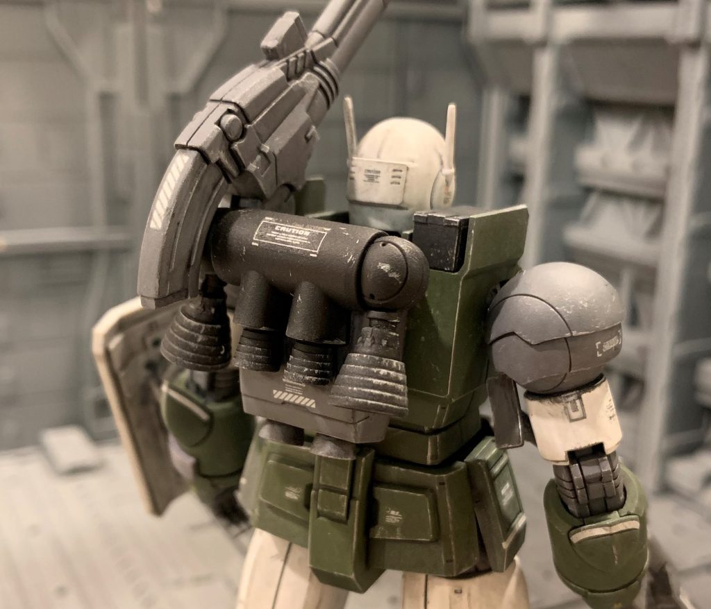 バックパックは特殊部隊向けに開発された高出力のジム・ナイトシーカーの物がベースに使われ、ルナツーの在庫部品を利用し組まれています。通常のジム用のバックパックでは本体重量分ジムより遅くなってしまう為、6基ものバーニアを備える高出力型をあつらえたという設定です。(前回のリアルタイプジム製作で余ったナイトシーカーの部品を供養する為です 笑)ナイトシーカーのバックパックからサーベル取り付け部を削除し、接地面をプラ板で形状変更しガンキャノンの背中にピタッと合うよう修正しました。他キットのバックパック同様、側面に各種モジュール装着用の穴を空け、そこにオリジン版ガンダム付属のショルダーキャノンを取り付けています。タンク横のバーニアはアームから先を付けず、ビルダーズパーツのバーニアを直接付けました。バックパック下部もナイトシーカーはただ2つ穴が空いているだけで貧相だったので、バーニア部品を接着し高出力感を増しました。