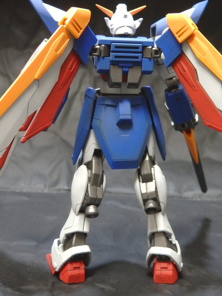 今回試しているのは『下地に暗い色を吹き、塗装は明るい色を薄く吹き、下地の影響を利用する』です。サフは吹きません。この方法は『調色なしでも全体の色合いを渋目にする』効果を狙っています。下地にMrカラーのオリーブドラブ(2)を吹いた上から、白:MrカラーのMSホワイト赤:MrカラーのMSレッド青:Mrカラーのキャラクターブルーを調色せずに吹いています。オリーブドラブの影響を受けて、渋い色合いになっていると思います。黄色と黒は下地無しで吹いています。黄:MrカラーのMSイエロー + ごく少量の赤黒:ガイアカラーのスターブライトアイアン