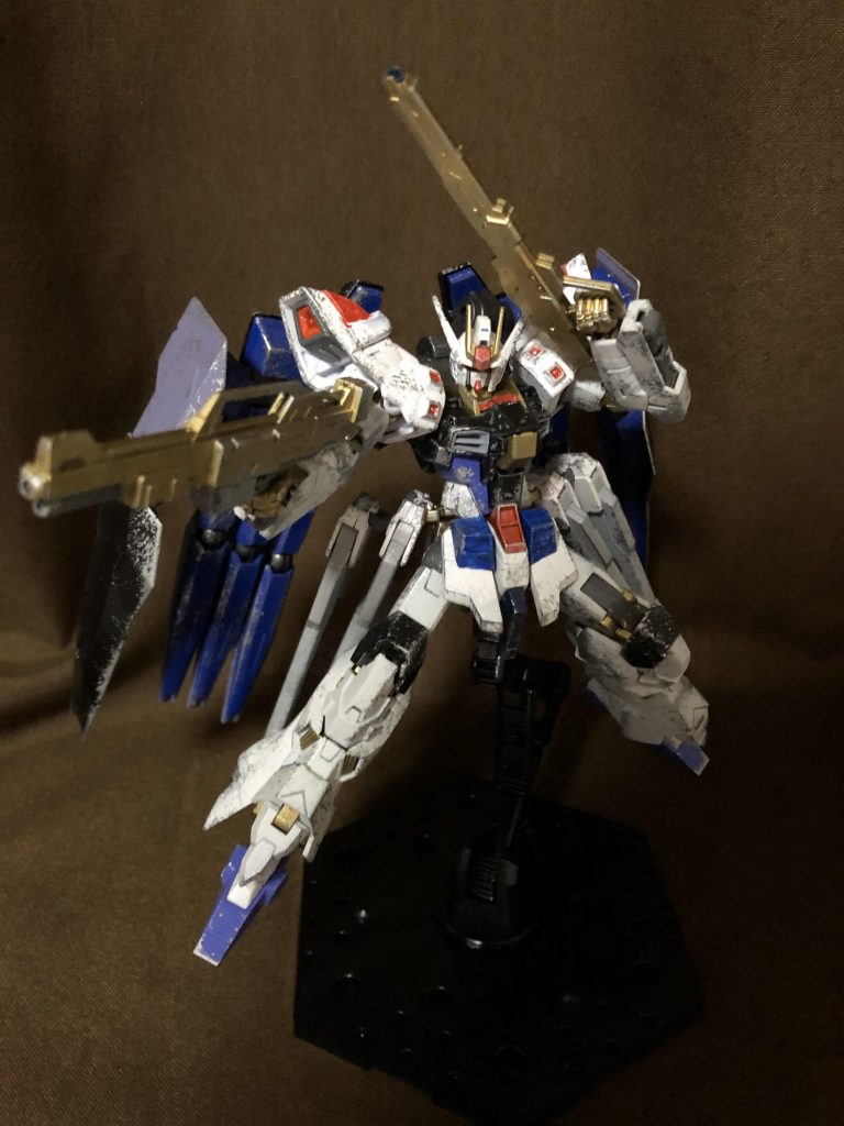 武装紹介《高エネルギービームライフル アルスター(左手)》標準的なビームライフルに、高機動戦闘に対応できるように改良した専用装備。特徴的な金色の銃身はヤタノカガミがごく微量ながらコーティングされており、破壊されにくくなっている。《高出力ビームマシンガン ケーニッヒ(右手)》連射性と火力に特化したビームマシンガン。威力こそ一般的なビームライフルを遥かに凌ぐ性能を誇るものの、一方で精密射撃にはあまり向かないことから、できる限りパイロットを殺さずに無力化する戦法を取るキラは当武装を必要に迫られた局面のみ使うことが多い。