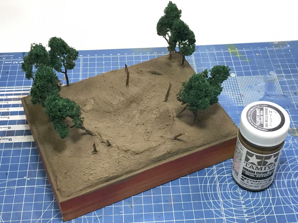 タミヤの情景テクスチャーペイントを塗って地面を作り。爪楊枝の木にシタデルシェイドを染み込ませてそれっぽく