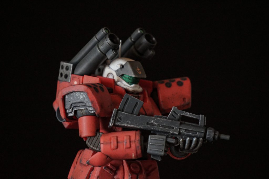 頭部バイザーは元のパーツにツインアイっぽいスジボリをしてシルバーで塗装後、クリアグリーンの包装フィルムを巻いてレンズ感を出しました。肩アーマーにはシャッター状の装甲で腕の可動に影響が出ないよう蓋をしました。ブルパップマシンガンのトリガーに指を掛けられるよう、人差し指の角度を調整しました。