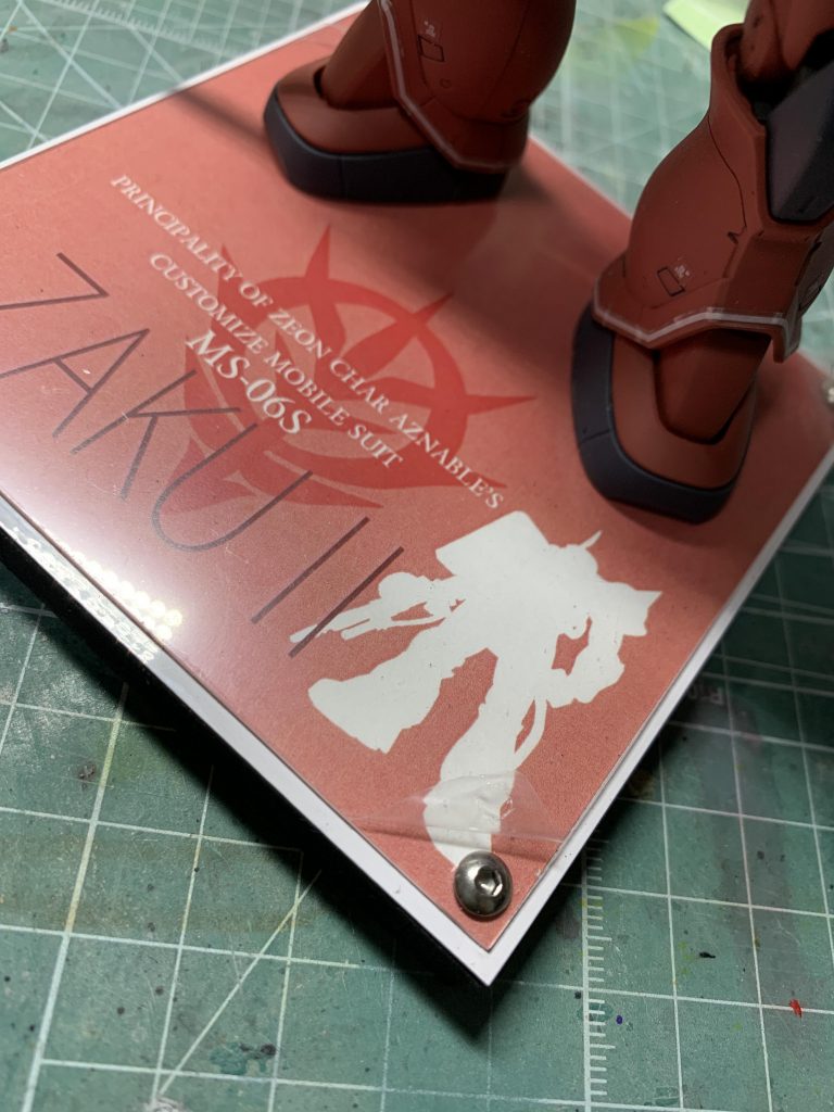 ゴムのベースの上に鉄板、ネットで拾ってきた画像を加工してプリント、透明塩ビにはさんでビスを四隅に装飾。台座があると拙いドノーマル完成品も幾分クオリティが上がって見えますｗ