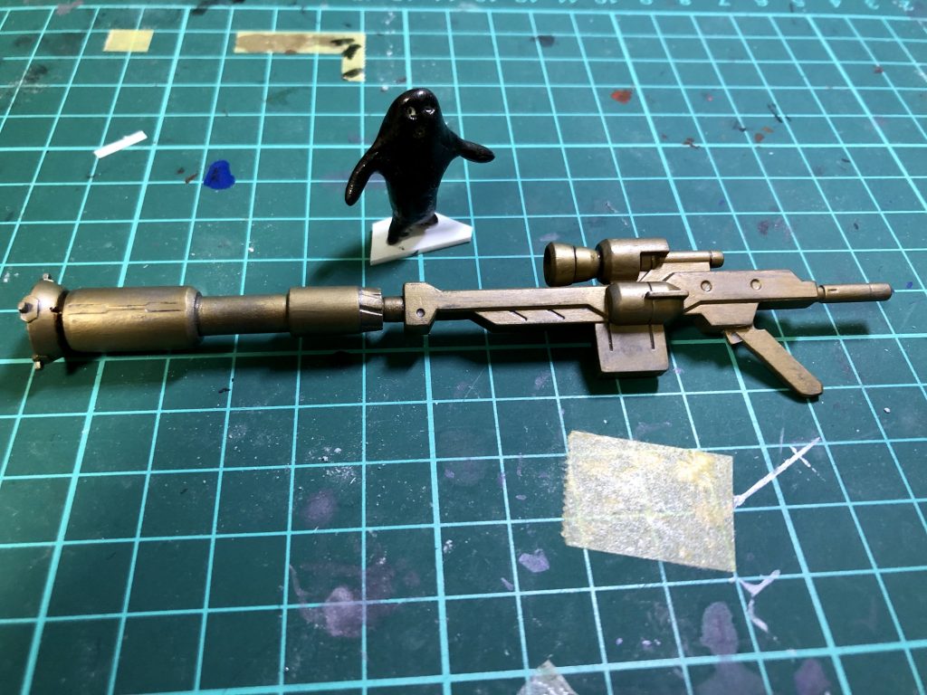 ヴィダールのライフルをベースに、バレルを付け足したり、持ち手を合うようにスクラッチしたりしました。ガンダムマーカーの古い方のゴールドを、塗料皿に出して平筆でバッサバッサに塗ったところです。