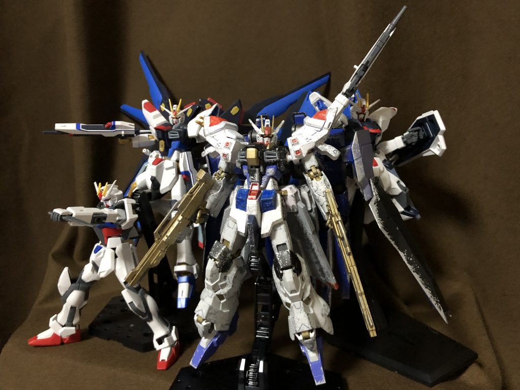 歴代キラ搭乗機とパシャリ。ここからは余談ですが、本作品の制作にあたって『キラが最後に乗るとしたらどんなMSがいいのか』というインスピレーションを得るべく久々にガンダムSEED全話を見返しました。いやぁ、自分の中でキラはどちらかというとDESTINY以降のどこか達観したようなキャラクターのほうでイメージが固定化されてしまっていたんですが……こう改めて無印の頃から見返してみると、なんというか本当に報われない子なんですよね。のっけからいきなり親友と殺し合いをさせられるところから始まり、友達を守るために戦いから逃げることも艦を降りることも許されず、守るべき友人達や味方からも『キラはコーディネーターだから』とどこか遠巻きに扱われ……控えめに言って普通の人なら人生終えたくなる不憫っぷりですよね。私自身はシン推し過激派なファンだったこともあり、DESTINY最終話放送当時こそ「さすがストフリ無傷エンドは、ラクシズのお家芸だな！(精一杯の皮肉)」などと言ってあまりキラに良い印象を抱いていなかったんですが、ちょっと前に友人とSEEDについて語っていた時に『あの最終決戦でストフリが無傷のまま勝利して終わったのは、実のところキラ達にとっても本意ではないのではないか』『虚しき完全勝利』と言っていたのを聞いて、DESTINYにおけるキラの印象が自分の中で360度くらい変わったような気がします。これはあくまでも妄想なんですが、もしかしたらキラも勝ち続けているように見えて、その中で無印SEEDの頃と同様にひたすら精神を磨耗してしまっていたのかもしれない……と。そう思えるくらいにはキラというキャラクターを前よりも冷静に視ることができるようになっていたので、今回ガンプラを作るためとはいえ色々発見があってよかったです。まあ、この新しいフリーダムで戦ってもらおうとしているんですけどね(鬼畜)