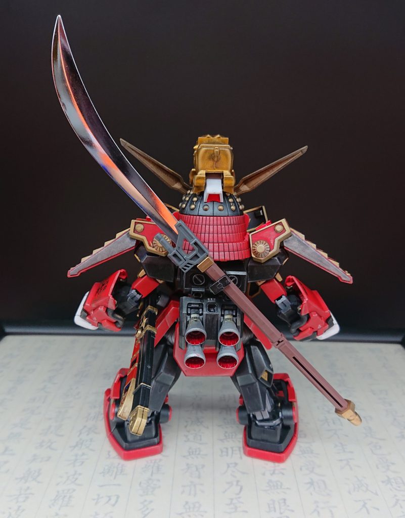 今回は、レジェンドBB武者頑駄無(頭、兜、肩甲冑、)、HGガンダムMk-Ⅱ(腕、胴体、脚)とMGガンダムMk-Ⅱ(腰)と真武者ガンダム(甲手、腰甲冑、足、薙刀、バックパックの下部分)、BB戦士烈火武者頑駄無(アンテナ、バックパックの上部分)を混ぜてます。また、農丸なので、BB戦士隠密忍者農丸から眼帯と頭の上のアニマルスピリッツ(シーサー)を拝借。武器は、武者摩亜屈(マークⅡ)に二刀流を伝授したという設定なので、腰に日本刀2本を装備しています。腕の可動はしますが、今回は立ち姿重視です💦