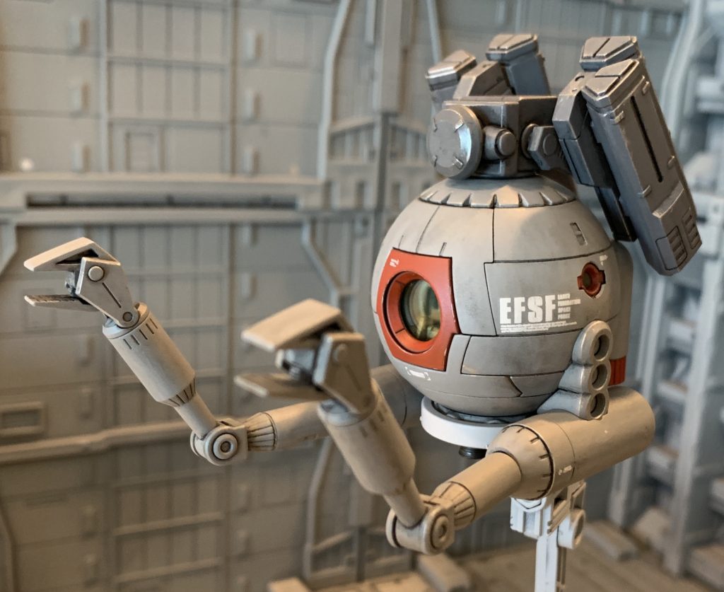 人力で誘導する特性上、人間の反応速度の限界から弾速は他兵器に比べて遅いです。その為、MSをはじめとする小型機動兵器に対しては命中が非常に困難で実用的ではなく、原則対艦、対施設用兵器としての運用になります。状況が揃えば、その身を危険に晒す事無く敵艦のエンジン部や艦橋をピンポイントで狙撃でき、中世代的で簡素な仕組みの兵器といえど侮れない脅威となり得ました。ミノフスキー粒子散布下での運用が前提とされており、コスト削減の為ミノフスキー粒子に阻害される電磁波を使用した誘導方式は搭載されておらず、弾速の関係から直接照準も使い勝手が悪く、非常に限定的な状況でしか活用の場が無かった為、投入された機数は極少数にとどまりました。