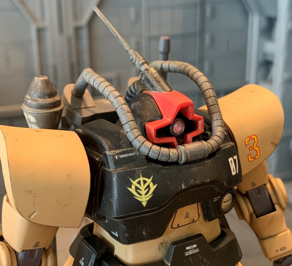 バックパックから延びる動力パイプを上手く口元に持ってくるのに少し苦労しました。当然ですがそのままでは角度と長さが合わなかったので、パイプと同径同色のランナーを繋いで延長、途中で一度ポキッと折って再接着し角度を微調整し、違和感ない位置に持ってきました。全部色塗ってからノープランでぶっつけ本番で工作したので緊張しました(笑)アンテナ部はMSVキットのままだと後頭部へのパイプが短すぎたので、同様にランナーで延長しましたが、接地面はほぼ隙間なくHGドム頭部にフィットしたので、接着剤でちょっと溶かして密着させたら隙間ゼロで装着できました。モノアイはベースをドリルで掘り込み、エナメルのシルバーで塗り、MSサイトレンズのピンクを薄く削って貼り付けています。モノアイシールドは付けず、モノアイを動かしたい時は細い棒等で直接モノアイを動かします。