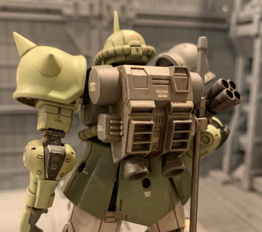 そこで、補助ジェネレータと強化推進機、及び大型推進剤タンクを搭載したバックパックに換装した、という設定にしました。開戦当初、高機動型ザクのバックパックの地上転用を検証する為に持ってきていた試験品をベースに改修したという設定です(オリジン世界では、ルウム戦役で既に高機動型ザクが実戦配備されていましたのでアリかと)。HGUCの高機動型ザクのバックパックが家に転がっていたので、利用する為に都合の良い設定を妄想した次第です(笑)HGUCの高機動型ザクのバックパックを使い、両側の整流版をカットしたり宙間姿勢制御用っぽいサブスラスターを削り取ったり、天面の取っ手を削り取ったりと、宇宙用っぽいディテールを省いて陸戦用っぽくしました。さらにヒートサーベルラックを増設しました。動力パイプはHGUC高機動型ザクの物をカットし、折り曲げ部の切り欠きをパテで埋めました(かなりやっつけで雑なのは反省点です)。