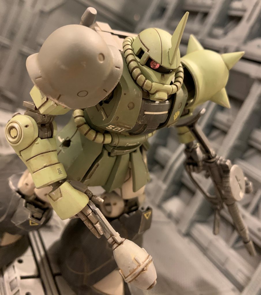 モノアイはレールをくり抜き、ビルダーズパーツのMSサイトレンズを嵌め込み、裏側にキット付属のホイルシールの銀色部をあてがいました。私の中でこの工作が1/144キットのモノアイ改造の基本になりました。MSサイトレンズはモールドがあったり中央に窪みがあったりするので、いかにも「カメラ感」が出ていい感じだと個人的には思っています。ちなみにシュツルムファウストと持ち手はHGUCの地上戦セットのザク手首を流用しています。