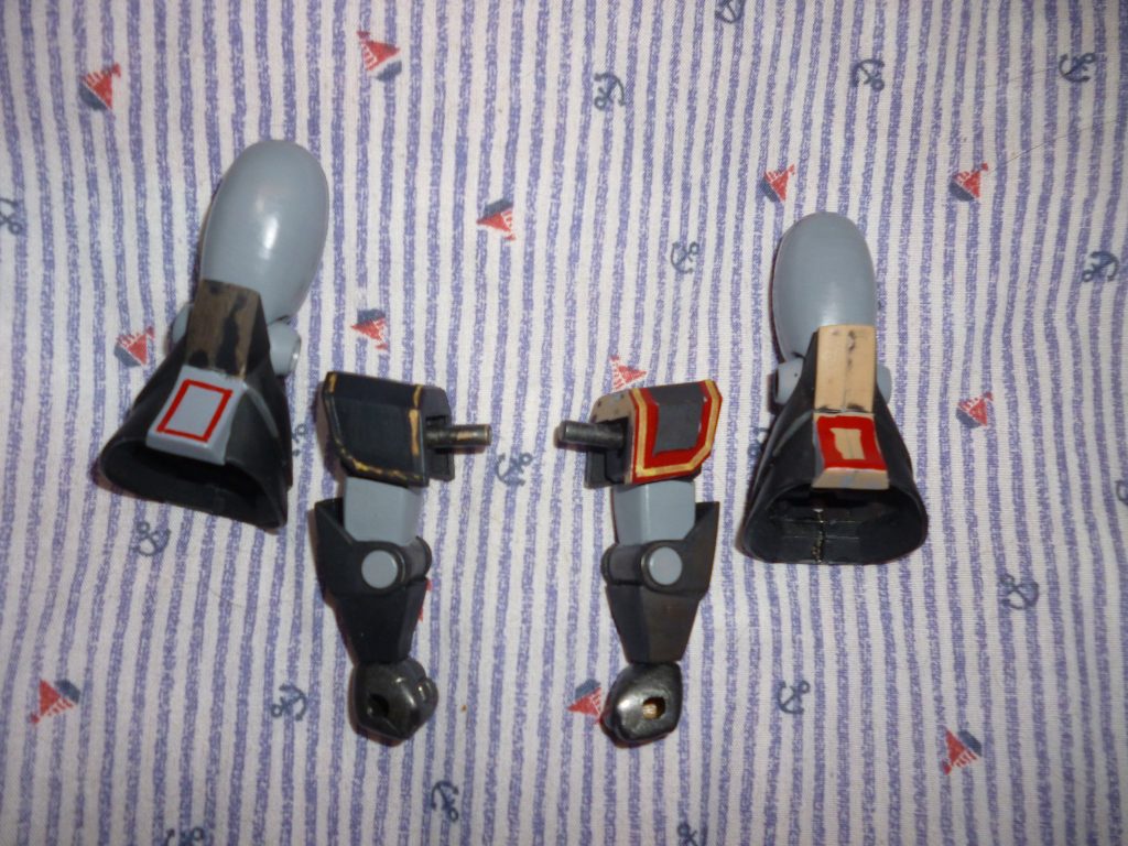 ラインマーキングを手描きです。今回、肩アーマーとスネの赤いラインをマスキングと筆塗りで再現してみました。手順としては、まず大ざっぱに赤いラインを筆で描き込み(画像右の脚)、塗料が乾いてから、赤色を残したい部分を細切りにしたマスキングテープで保護します(画像右の腕)。次にマスキングの上から、マスキングテープごと本体の色を塗り(画像左の腕)、本体色が乾いたら慎重にマスキングテープをはがします(画像左の脚)。完成写真などでじっくり見ていただきたいのですが、個人的にはかなり上手くいったと思っております(笑)!