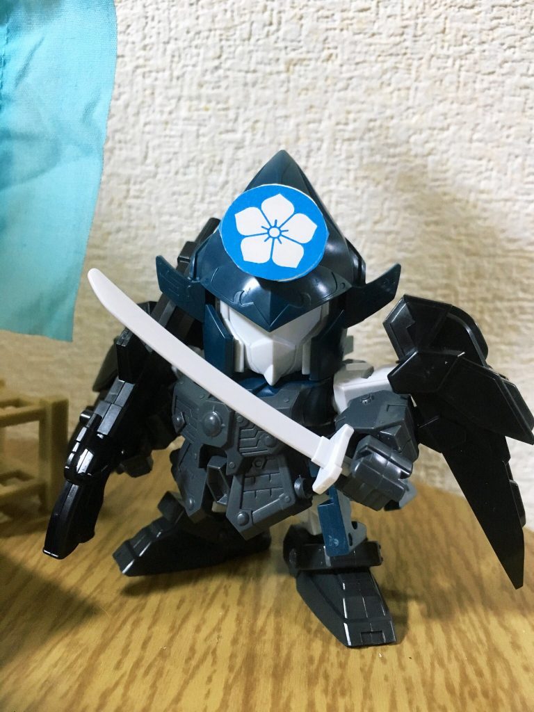 今回は織田信長頑駄無の魔王感溢れるデザイン・カラーリングを意識して、信長の右腕たる参謀イメージでSD武者烈伝・天翔狩人摩亜屈(マークツー)をベースに製作しました。摩亜屈ベースは武神降臨編・直江兼続頑駄無と重複するため、付属の刃斬武(バーザム)将軍の甲冑パーツや別売り互換パーツ「武化舞可の鉄肩」などを組み合わせて差別化を図りました。