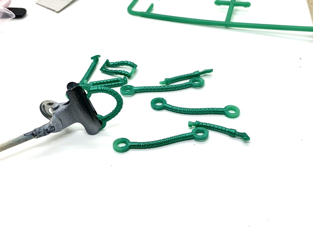 軟質パーツ(TPE)もアクリジョンのメタリックグリーン(一部ホビーカラーのゴールド)で塗装してます。曲げてもすぐに剥がれたりしませんでしたが、墨入れ後に綿棒で拭き取りしたらかなり剥げました。剥げた箇所は筆塗りでリタッチしてます。ミッチャクロンとかのプライマーを使えばもっと耐久力上がるのかな?