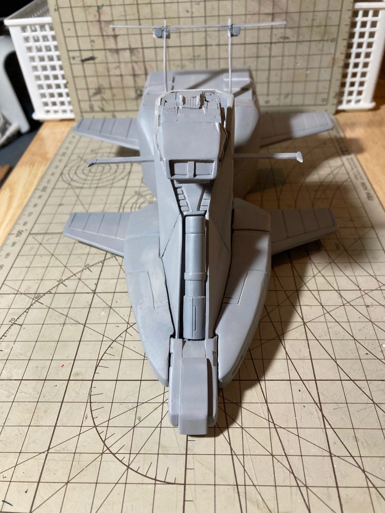 【製作工程7】サフ吹き後の画像です。カラーはアクリジョンベースカラーの白と青のエアブラシ塗装がメインです。全体的にのっぺりした印象だったので、エナメルのつや消し黒で軽くよごして立体感を出し、それでも物足らずシュラク隊オリファー隊長のパーソナルマークを貼ってみたのでした。