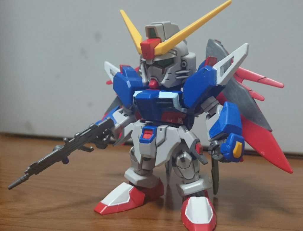 という訳で、ドM企画弾1弾のSDEXデスティニーくん。塗装した箇所は……・レッド……頭部アンテナ中央、肩、腹回り、股間、サイドアーマー、名無し砲のお尻、アロンダイト・名無し砲の△・ブルー……前腕～マニュピレータのガントレット、股間、脚、バックパック基部・イエロー……手甲ビームシールド基部・ホワイト……フラッシュエッジ、足、アロンダイト先端・ライトブルー……胸のライン、アロンダイト・ダークグリーン……名無し砲・グレー……胸部ダクト、マニュピレータ、足首関節、バックパックアーム&マウントラック、ライフル・ヘビーガンメタリック……バックパックスラスター・ブラック(マーカーブラックは後でぼろぼろ剥がれるのでグレーで塗装)……翼、サイドアーマー、膝・ブラック(こちらはホントにブラック使用)……ツインアイ・ルミナスメタグリーン……ツインアイただ、ちょ～っと手抜きもしてたり具体的にはライフルのホワイトとレッドとか、名無し砲のセンサーとか、ブラックの部分をグレーで塗ったりとか、バルカンをスミ入れだけでグレーに塗らなかったり(これは最近の好みというのもある)……