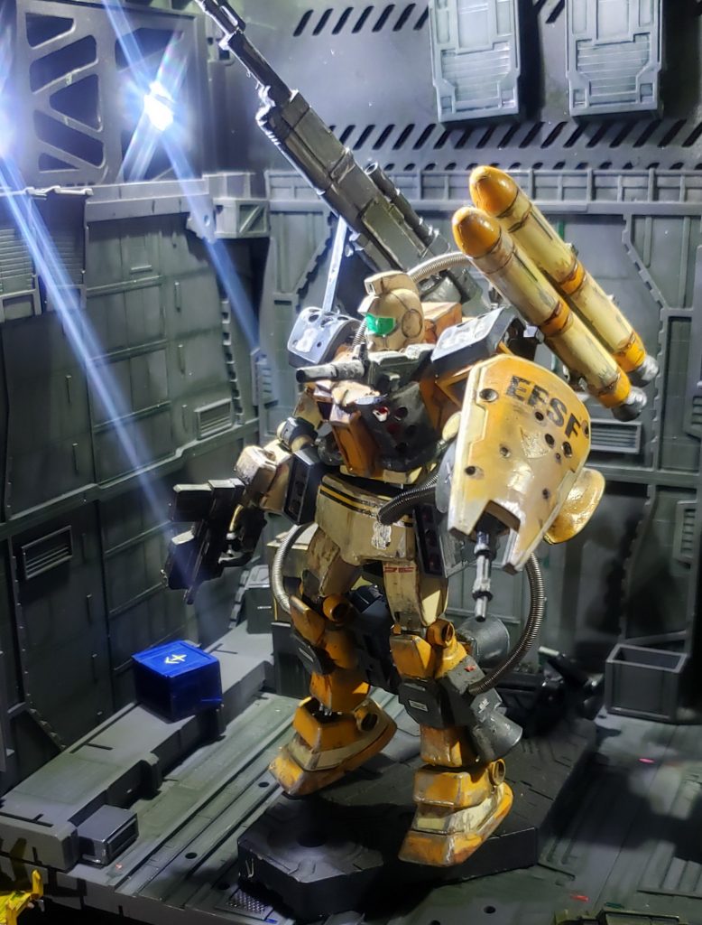 中破したノーマルジムをベースを、残っていた予備部品、鹵獲した敵機体の廃材等で強引に改修しています。また、単機で敵空軍部隊に突貫するためにありったけの武装を積んでいるので、破損した左胸には90mmマシンガンが、左腕はマニピュレーターではなくザクマシンガンが直接付けられています。