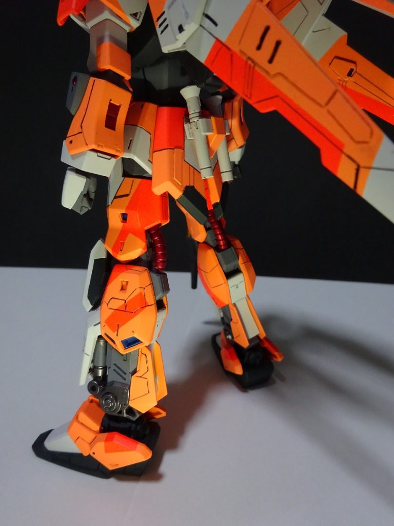腰~足回りをピックアップ。元々は赤色のパイプと膝部のスラスターをメタルレッドとブルーで塗装。ここにもオレンジの濃淡色でスプリットぽく模様を入れました。あと今回改めてですが、墨入れがうまいこと行かず。パチ組の延長で、墨入れペン、墨入れ用シャープペンを使ってましたが結構汚れが残ったりと課題が残る出来に。