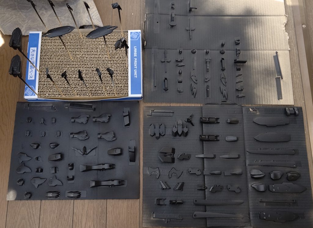 外装パーツはまとめて缶サフを吹きました。後に塗装するパーツは塗装ベースに差し、残りは段ボールに両面テープで貼り付けた状態で一気に。1200の黒サフが手触りも色艶も最高なので、黒はこのままでいきました。