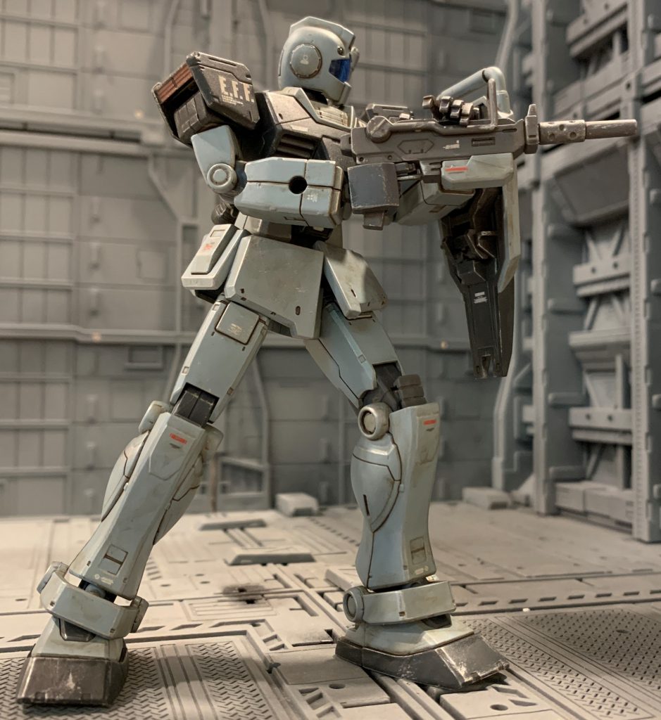 ホワイトディンゴ隊ジムは作品や商品によって本体カラーが全然違います。ガンプラの中ですら、HG版とMG版で全然設定色が違います。最初は元祖であるゲーム版のCGをオマージュして紫がかったグレーを目指したのですが、エアブラシは持っておらず筆塗りも自信が無く、たまたま見つけた模型用ではないグレーのスプレーが青味がかっていてなんとなくガンダムウォー版のイラストに近い色だったので、路線変更しました。