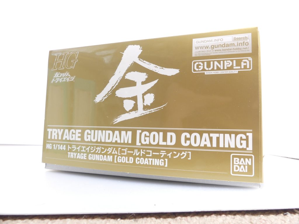 金！筆者です。「ＥＸ」期から何度も何度も話に上げていた金色の奴がようやく届きました。「ガンダムトライエイジ」９周年と同ゲームのシステムを利用したガンプラ・ガンダムTRYAGEマグナムの登場、そしてトライエイジオリジナルＭＳであるトライエイジガンダムの参戦を記念した特別ガンプラです。当選数は７～８月に99個×２、それ以降ちょくちょく少量づつ懸賞品となっています。本記事を書いている現在（11/30）もツイッターキャンペーンでプレゼントされていますね（～12/2）。･･･最速の第一回分に当選していたので（7/20）、8/20に応募先入力フォーム（カードダスドットコム）に入力して送信後･･･11/26に到着。ほぼ半年だぞこれ。TRYAGEマグナムの再販（11月）・トライエイジガンダムの発送（同月）と生産タイミングを同じにしたのが主な要因。箱はTRYAGEマグナムと同一パーツにもかかわらず厚ぼったくなっています。 