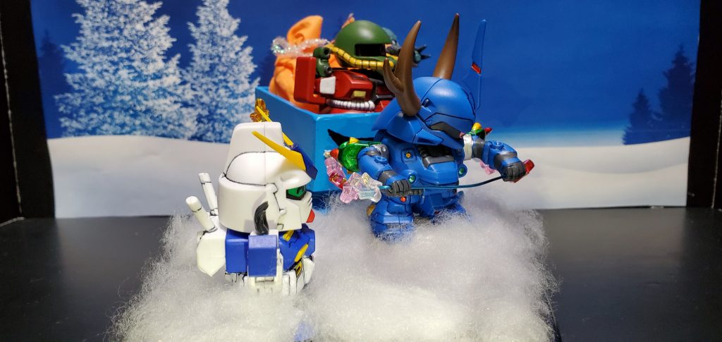 ポケ戦のキャラによるクリスマスです。ザクⅡ改はサンタ、ケンプファーはトナカイ、ハイゴッグはソリ、ズゴックEはプレゼントの一部、アレックスは楽しんでいる子供という設定で作っています。楽しいクリスマスということでみんな笑顔にしています。表情をつけられるのはSDガンダムならではですね！