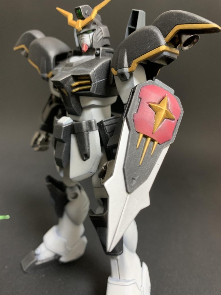 個人的に頭部と同じくらい手を入れた箇所がシールドです。アフターコロニー世界のガンダムなのに何故か初代ガンダムみたいな十字マークが付いてるバスターシールドです。これが元キットだと平面にモールド入ってるだけであまりかっこよく無い。ランナーの十字部分を削り出して自作しました。