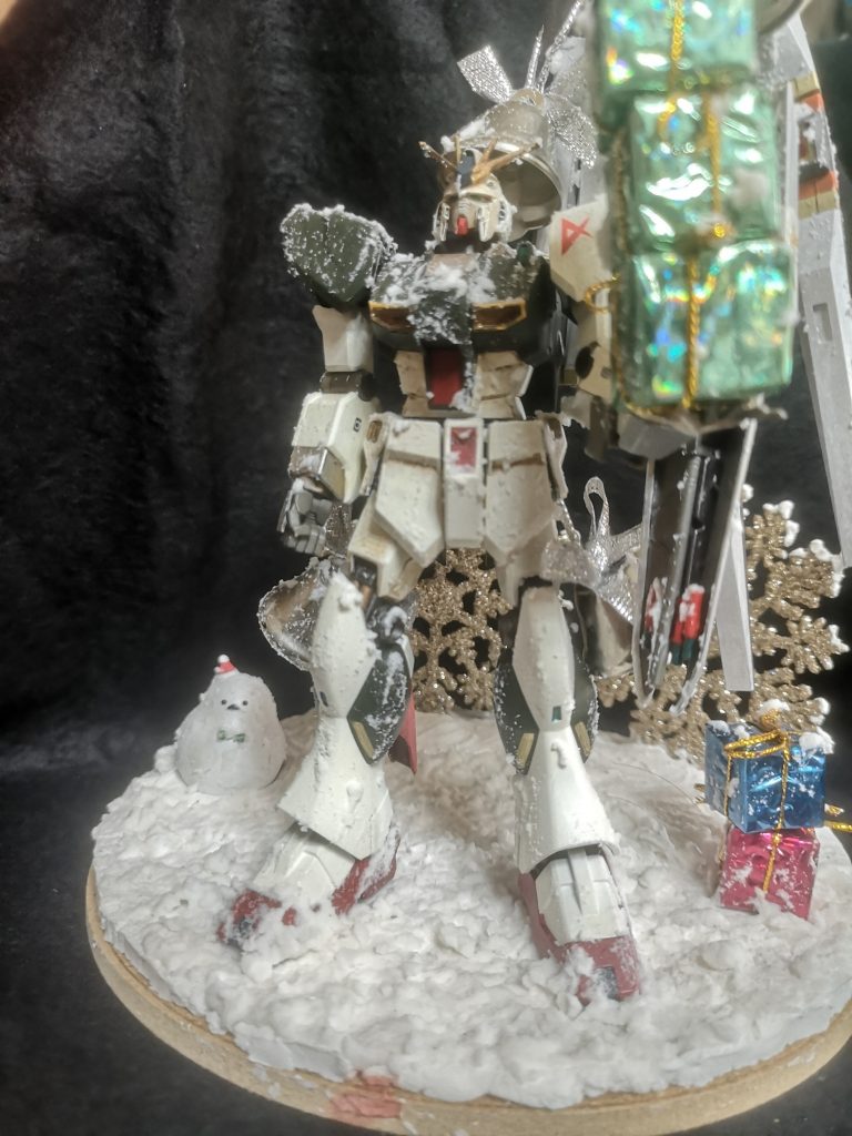 クリスマスカラーという事で緑・赤・金・銀で塗装。深緑と赤はギラドーガとサザビーを、左肩を白くしたのは両陣営の調和(=平和)をイメージしています。またプレゼントボックスも緑→サイコフレームの共振、青と赤→アムロとシャアのパーソナルカラーを意識しています。