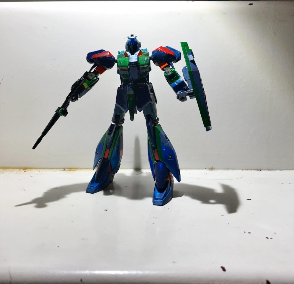 リガズィMK2リガズィ本体元のリガズィ同様腕にGNグレードランチャーを二基ずつ装備しているさらにGNビームサーベルを2本GNビームライフル(威力は抑え目だが敵の関節を装甲ごと砕くことは可能である)GNシールド(コロニーレーザーをも受けしのぐことが可能である。さらにアイテのビームを吸収し自分のエネルギーとすることが可能である)を装備している本機は小型核融合炉と疑似太陽路をハイブリット利用して動いている。パイロットは主に悪質な転売ヤーに恨みを持つものとアリスシステムによって構成する。さらにアリスシステムにはアリアス・サーチェスの頭脳がインプットされている。部隊隊長はアリアス・サーチェスの弟である。クロノア・サーチェスである。物凄い歳が離れている。ため本人は兄の存在を知らないし兄も弟の存在を知らない。彼は模型店を経営していたが悪質な転売ヤーにより商品が本当に届いて欲しい人に届かず、ユーザー情報が不明になってしまい店の仕入れの計算が破綻して閉店に追いやられしまった店の店長である根は兄と違い優しい正確であったがこの事を切っ掛けに自分の正義を正しいとしその正義を強行する考えにとりつかれその感情を見込まれ本部隊の隊長に任命された