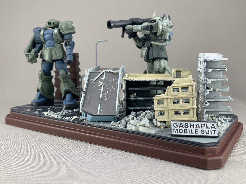 ガシャプラで新たにザク隊長機を作りました。
以前と同じくモノアイをつくり、肩を下げ、首を短くして左手は埋めましたが、今回ひじは固定。右ひじは曲げました。