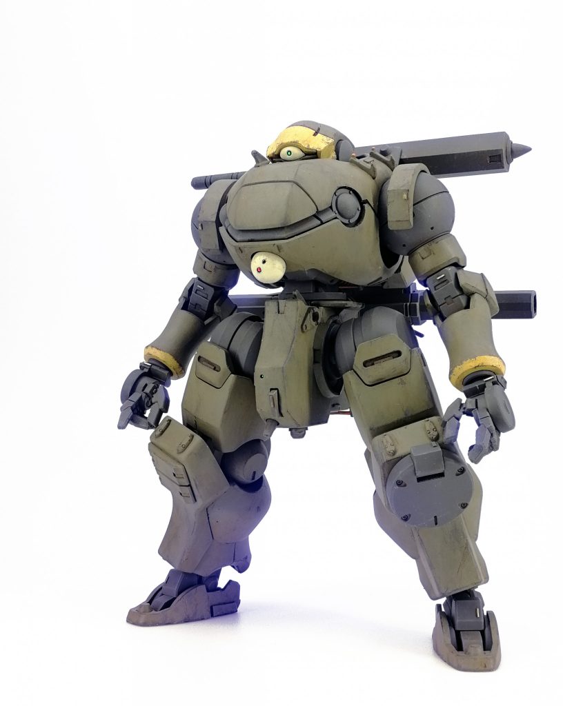 頭はオーガジンクスの下を半分ぐらい切り飛ばして短くしたもの。角も削りました。胴は大体ケンプファー。胸は上下反転してフンドシと接続。レフプレンと同じ。リーオー肩を埋め込むために腕穴を丸く大きく広げてます。腕は大体リーオーNPDのをそのまま。肩を胴に埋め込む感じにして一体感を高めました。手首はレギンレイズ用の平手を加工して右は2×3mmの銃持ち手、左は3×3mmの棒持ち手として機能するように指を調整してます。足は基本グリモア。太腿後ろを切り欠いてフレームをでっちあげ。膝の丸い部分を切り飛ばして正面装甲をフラットに。右は膝に増加装甲、左は予備マガジンを付けました。足首は百錬のフレームとフラッグの爪先、グレイズの肩あまーフレームで出来てます。全身の各部を戦車キットジャンクやプラチップでディテールアップ。塗装はフレーム色のメカサフヘヴィまでエアブラシで塗装し、ファレホでドライブラシとスポンジチッピング、オイルブラッシャーで汚しを軽く入れた後一度クリアでコート。その後メイン色や差し色をファレホで筆塗り、塗料の剥がれをファレホエアブラシシンナーを沁み込ませた筆や楊枝で擦り落として実際に剥がすことで表現。さらに油彩やウェザリングカラー、パステル等で汚しを描き込んでいきました。最後にマッキーペイントマーカーで金色を挿して完成。各センサーやレーザー素子をイメージした緑と赤には穴無しの0.5～0.8ｍｍビーズを使用。