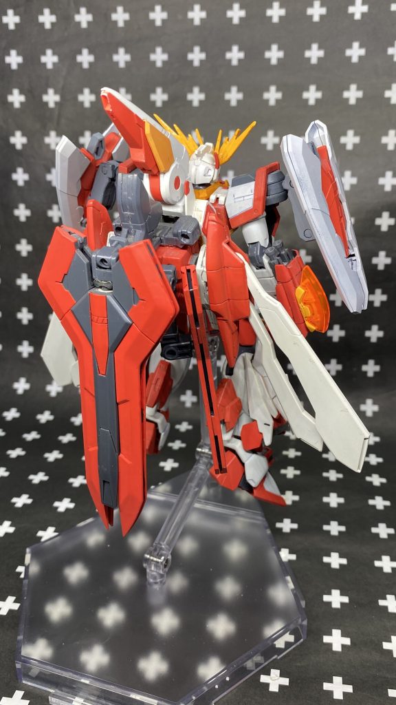 脚部はスターバーニングをベースに側面にユニバースブースターの肩部接続パーツを移植して接続。ジャンクパーツを使ったので何のパーツかは分からないのですがとりあえずボリュームが出るよう組み合わせました。肩部はトールストライクにトライスラッシュブレイドを接続。接続アームは短くしています。頭部はゴッドをベースにジャンクパーツで耳を付けたりしています。アンテナはフェネクスのものにジャンクのアンテナ類でボリュームアップしています。籠手はシャイニングをベースにウイングゼロ炎のパーツとトライバーニングの手甲パーツを使ってます。背面はすーぱーふみなのバックパックが3mm穴と大きさがちょうど良さげだったのでこちらをベースにユニバースブースターやジャンクパーツで接続部を増やし、側面にMGのゴッドのコアランダーの羽根部をボールデンアームズで接続しています。あとはM.S.Gのメガスラッシュエッジと忘れましたがコトブキヤキットの武器をジャンクパーツで接続しました。