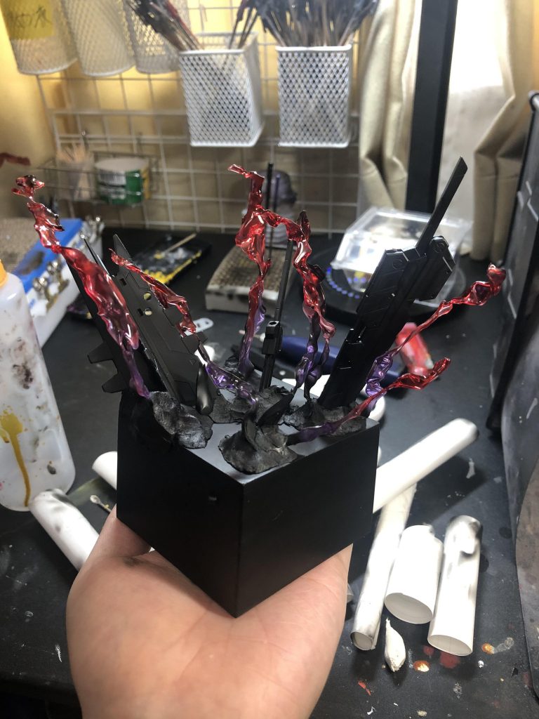 台座は百均の小物入れに上下に厚めのプラ板を何枚も重ねてくっつけてたものです。台座をヤスリがけでし整えて後は、ジャンクパーツを探して台座に穴開けて、開けた穴に武器を真鍮線やらなんやらで固定してます！後は目だ立たないように百均の石ねんどで刺さってるとこをいい感じに埋めて形は完成！