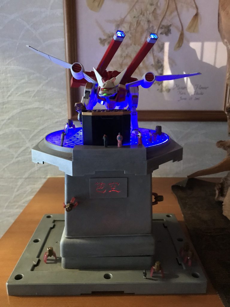 参拝をイメージしたベースです。
鳥居キャノンと交換式の賽銭箱兼稲荷寿司オートマトンポットはミサイル部分にオートマトンに変形する稲荷寿司(東北仕様の紅生姜な多脚を内蔵)を装備&射出する設定で、オートマトン(脚部を出す事によって外装の油揚げが少し萎んで皺々になります😆)は巫女さんや参拝者のお手伝いをします。
ベースの芭空部分だけでなくベース自体もグラデな感じで光ります。